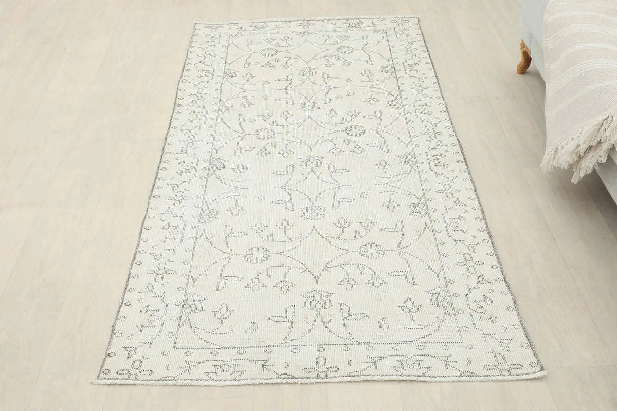 Full overhead view of the ivory and gray vintage rug, showing its complete design and proportions.