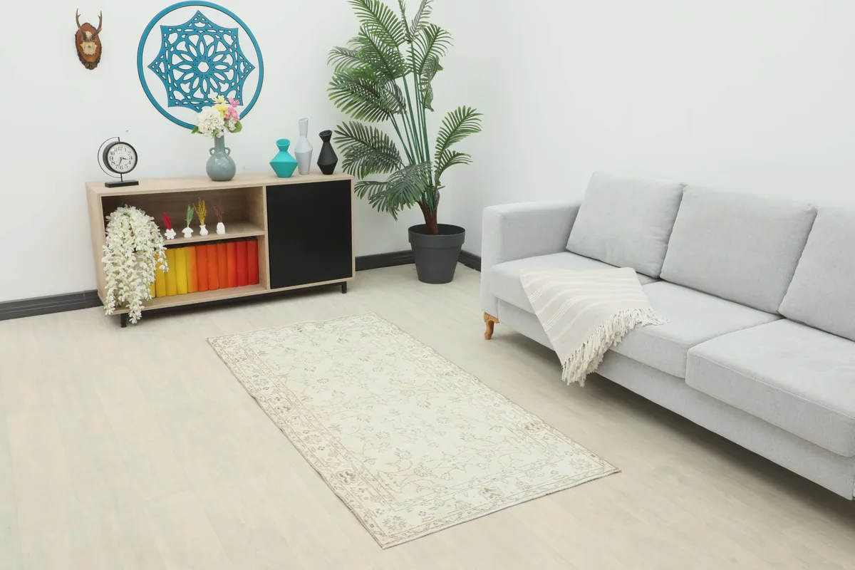 Beige Subtle Floral Rug in a modern living room setting with a light gray sofa and wooden cabinet.