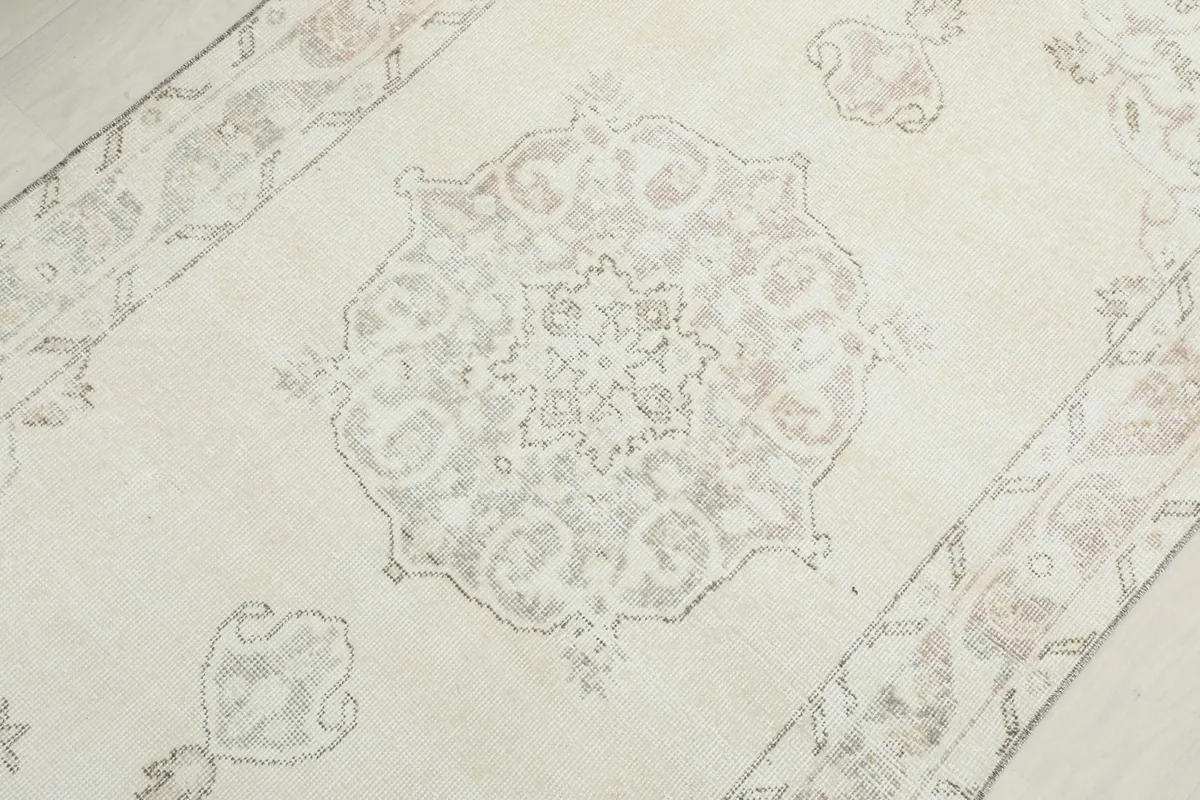 Close-up of the central medallion design on the ivory field, showing intricate motifs.
