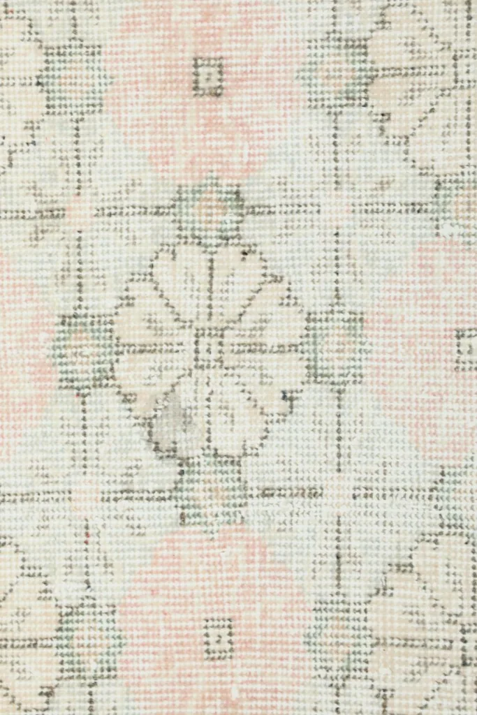Detailed view of a single geometric floral motif and the texture of the low wool pile