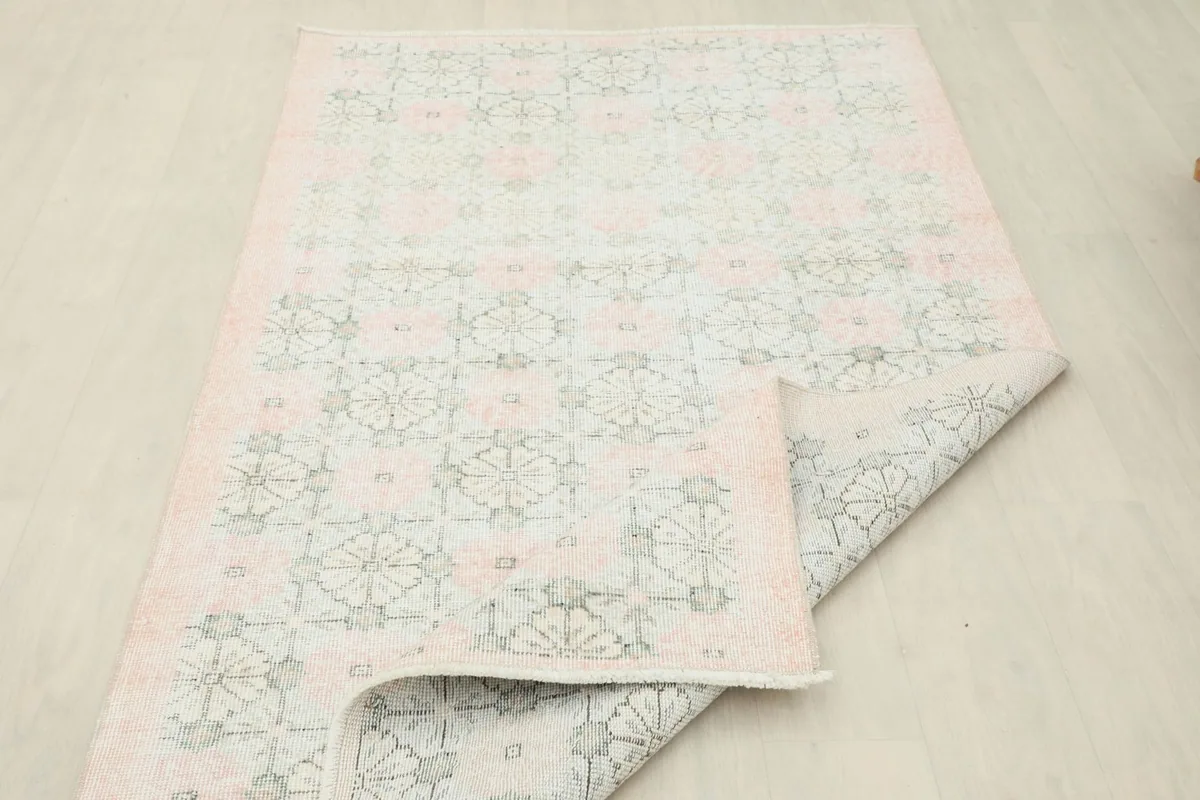 Partially folded rug showing the back of the hand-knotted wool pile on a cotton foundation