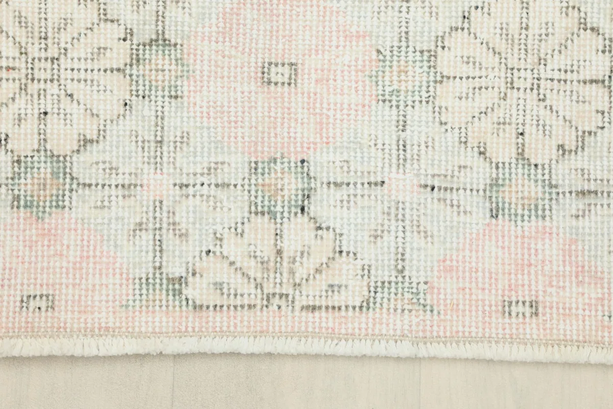 Close-up of the rug's edge, showing the short, natural fringe and the hand-knotted construction
