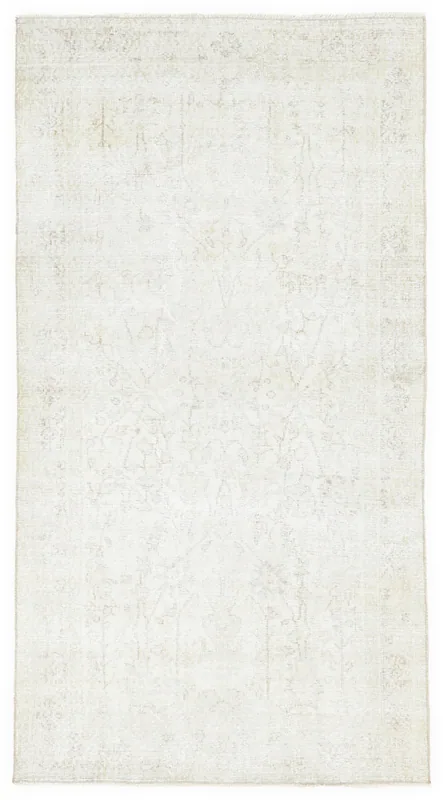 Full overhead view of the 4x7 ivory vintage Anatolian area rug with faded floral medallion pattern