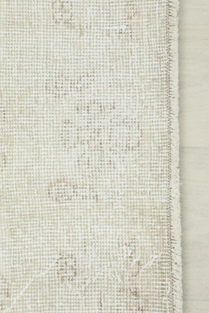 Detailed view of the rug's edge, showing the woven side finish and subtle border pattern