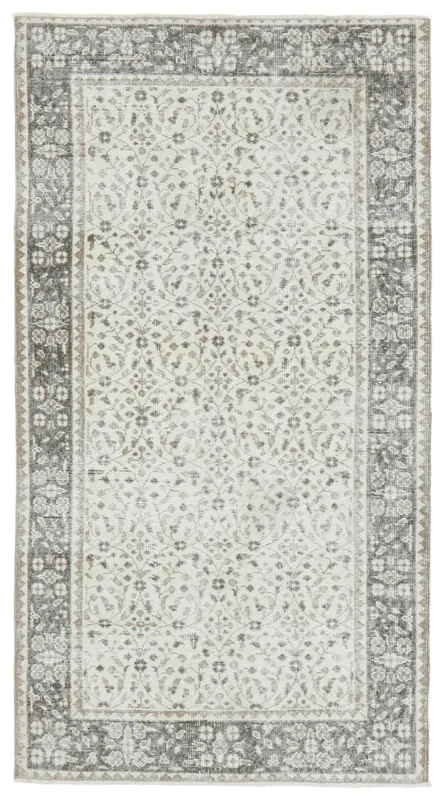 Full top view of the 4x7 ivory and gray floral vintage Anatolian area rug on a white background.
