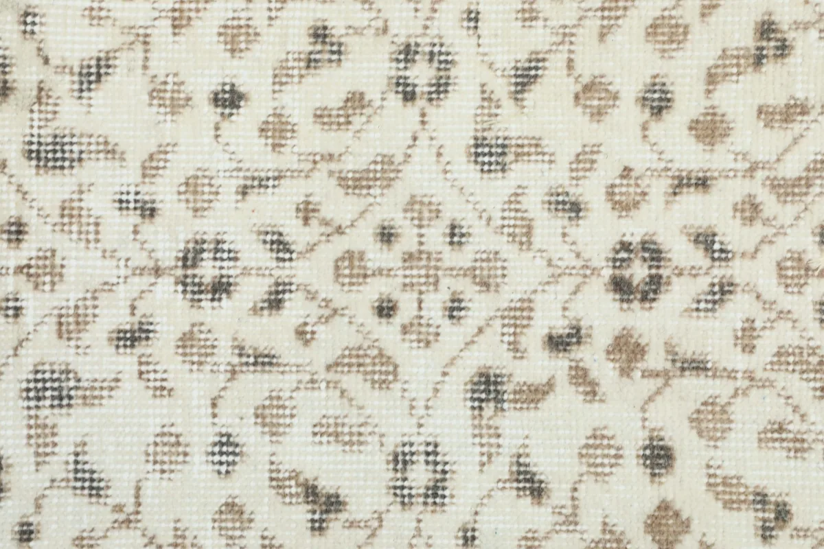 Macro shot of the rug's low wool pile, showing the hand-knotted texture and subtle color variations.
