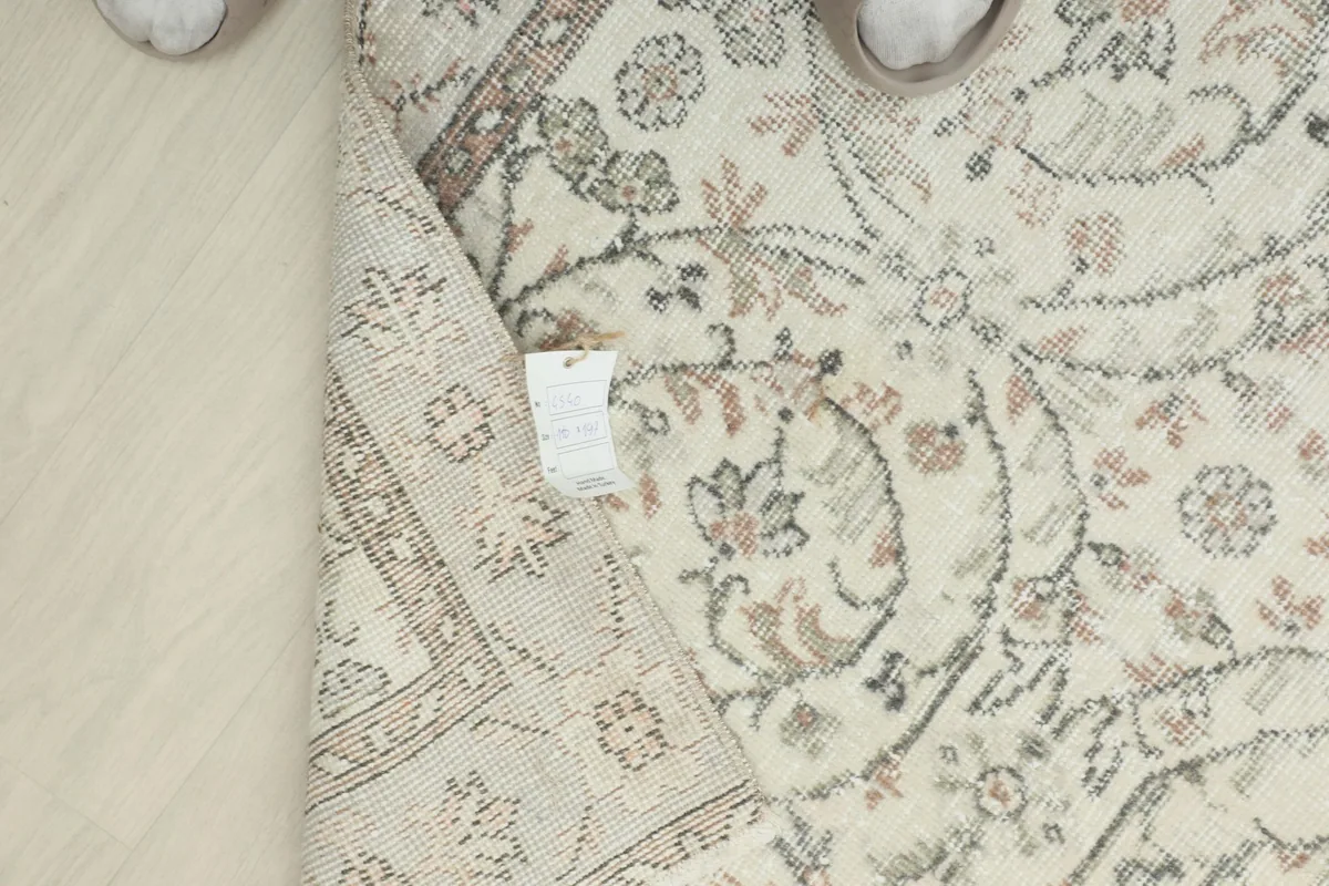 Underside view of the rug with a tag, showing the reverse of the hand-knotted wool pile