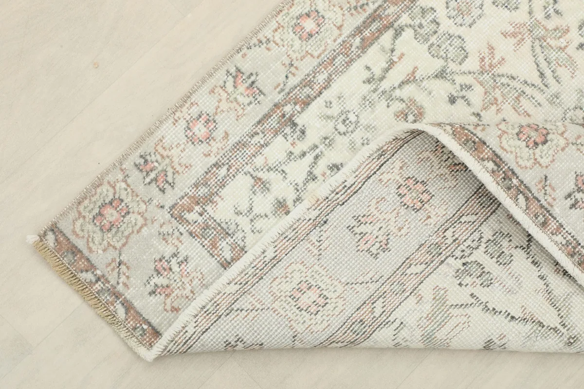 Corner of the rug folded back, showing the cotton foundation and hand-knotted construction