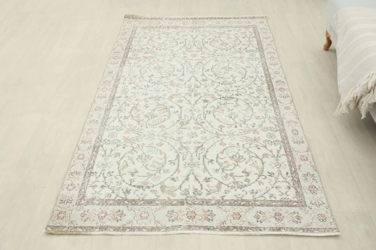 Overhead view of the ivory vintage rug laid out in a room, providing a full perspective
