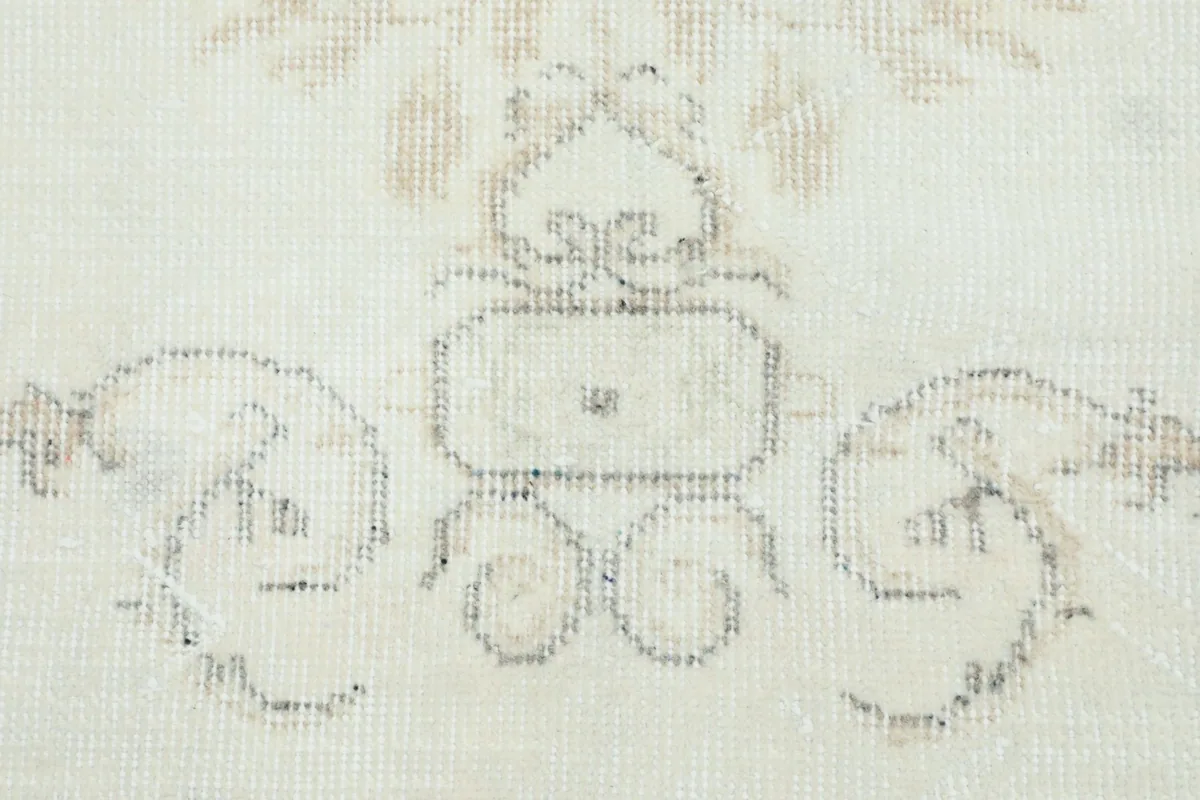 Close-up of a central medallion-like element and surrounding faded motifs