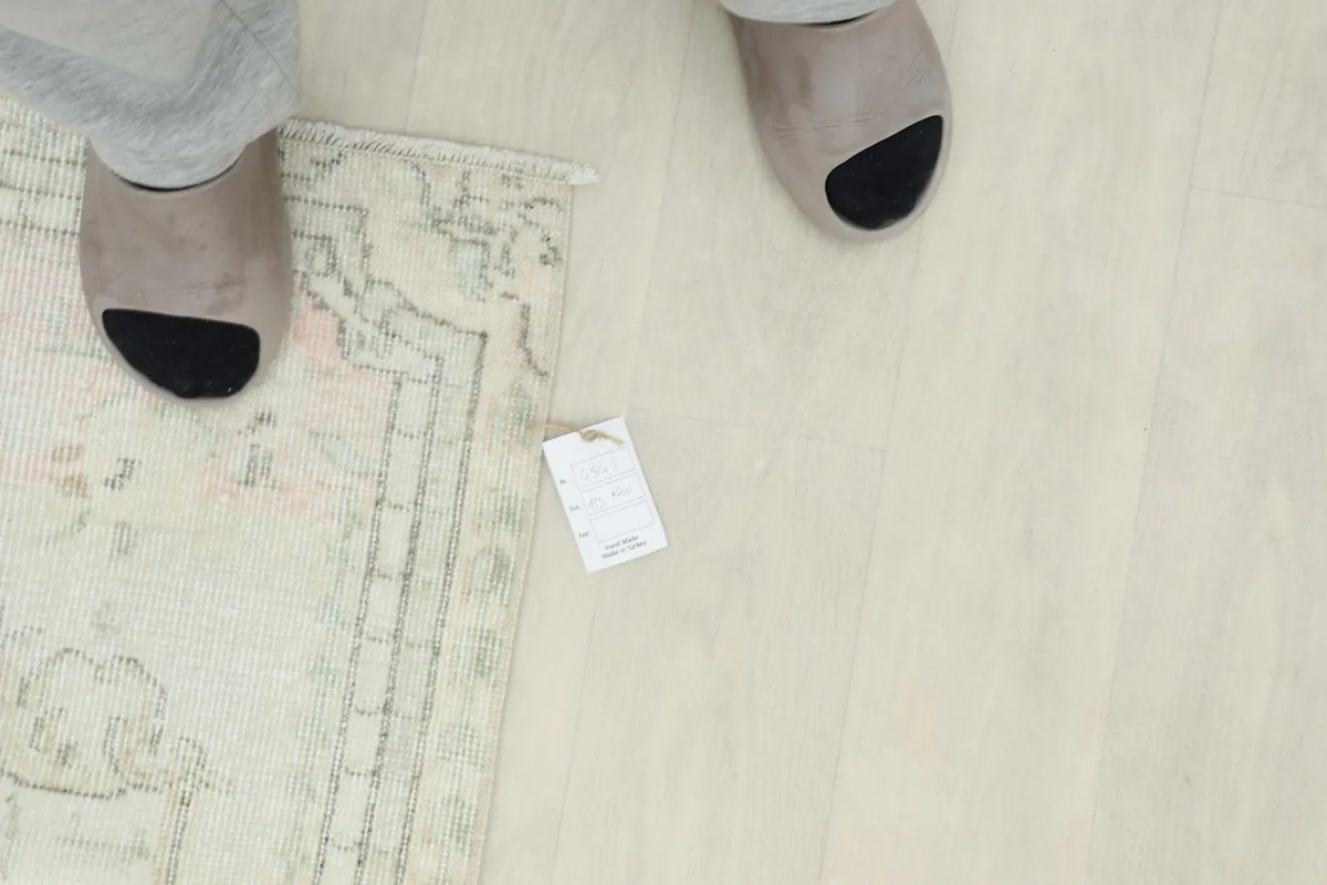 Overhead view of the low pile texture and a small tag on the rug