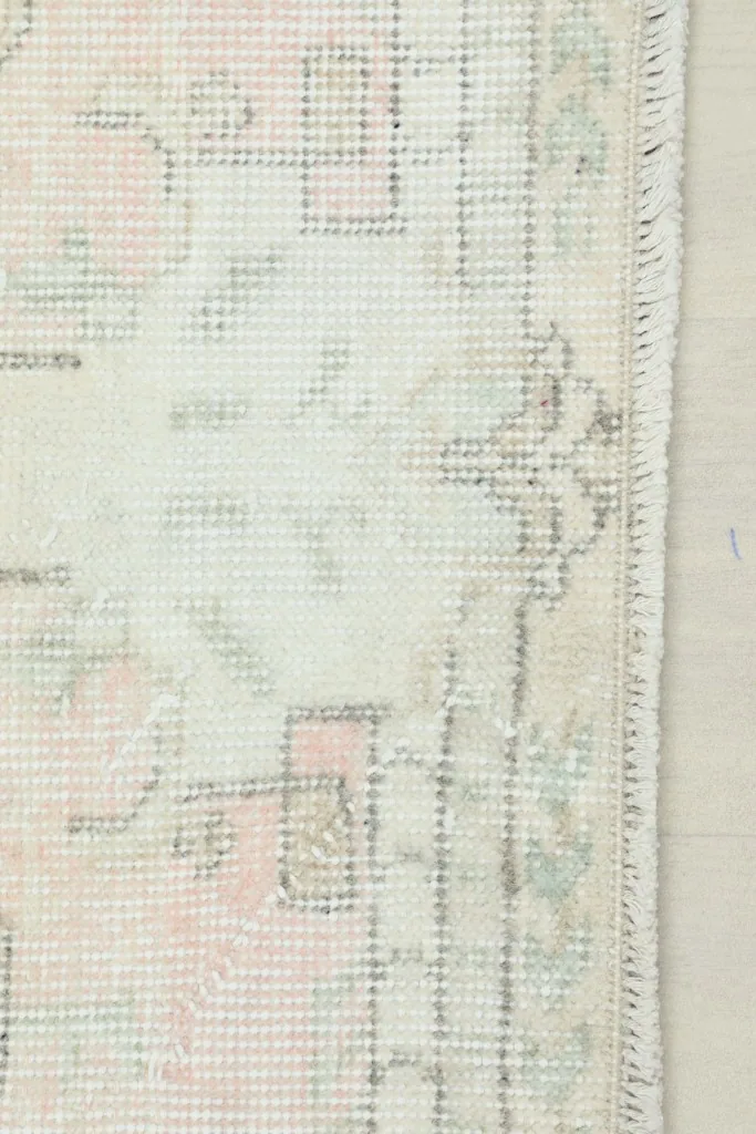 Close-up of the rug's edge showing the short fringe and part of the border design