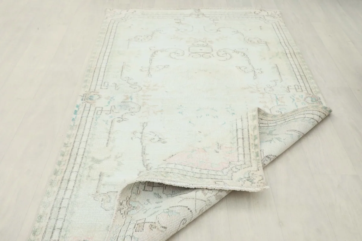 Folded corner of the rug revealing the thickness and construction of the vintage piece