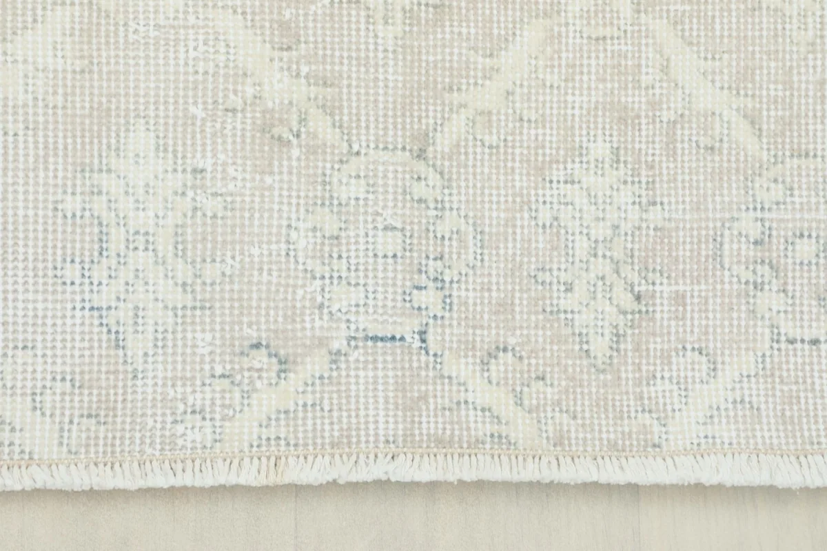 Close-up detail of the rug's subtle geometric pattern and short fringe edge