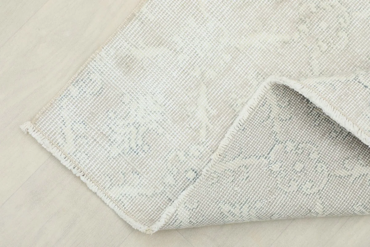 Folded corner of the rug, showing both the pile and the reverse side's weave