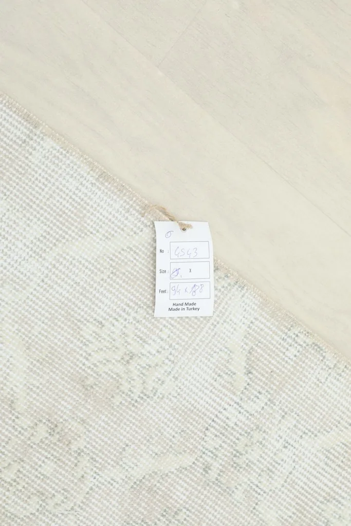 Product tag attached to the rug, displaying size and material information