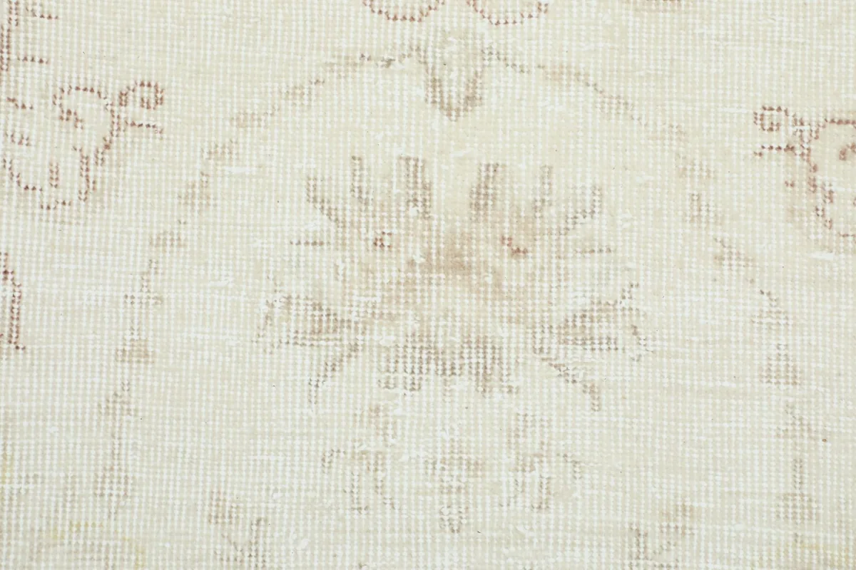 Close-up of the hand-knotted wool pile texture and faded rose patterns