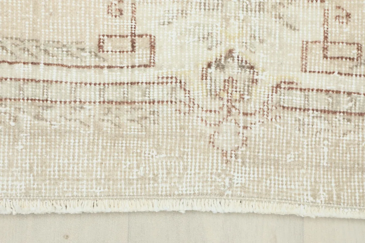 Detail of the rug's short, natural fringe and the edge of the border