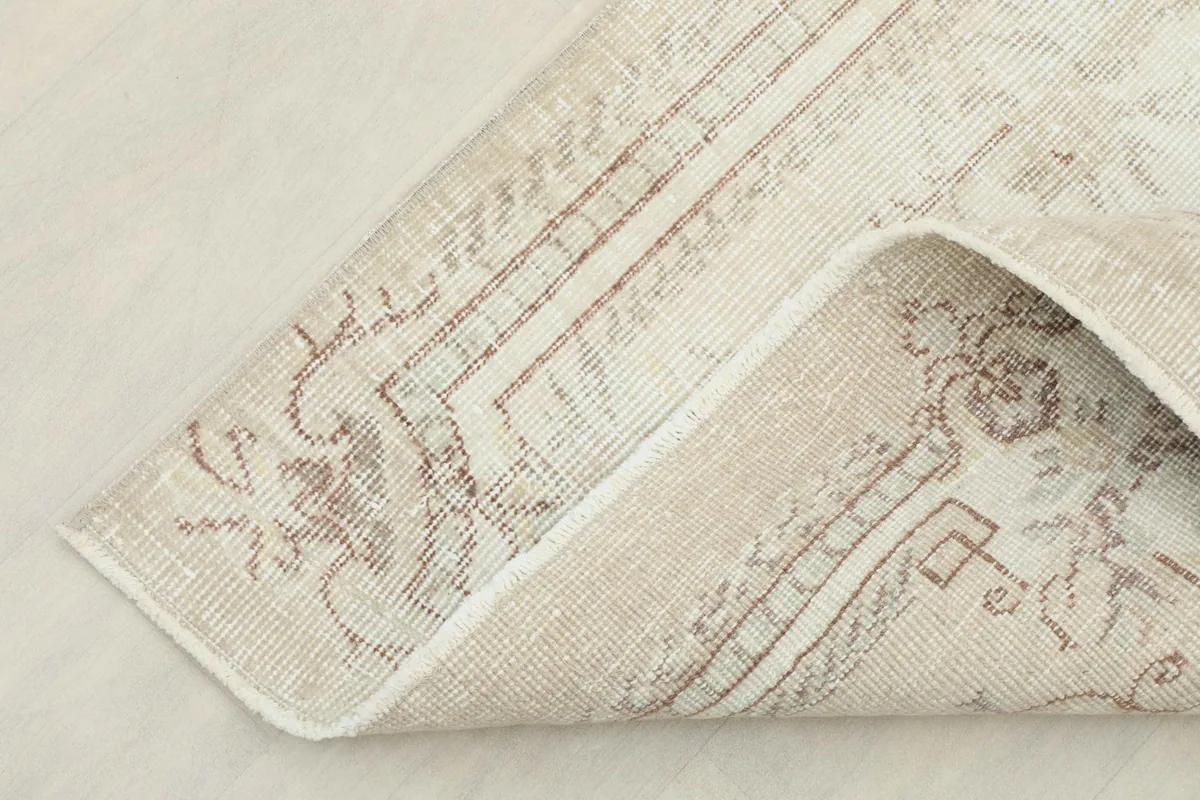 Corner of the rug folded to show the thickness and the back of the weave