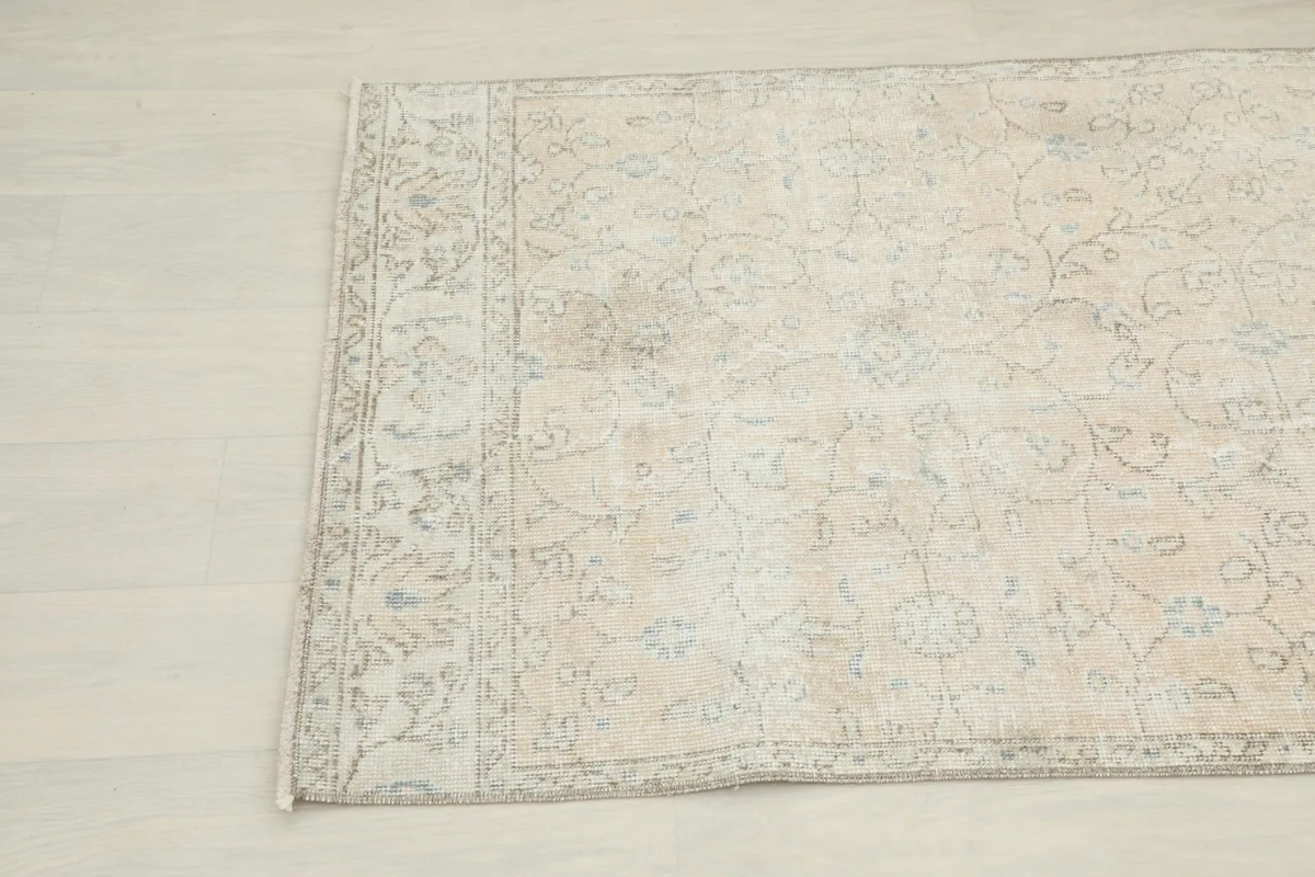 Detailed view of the rug's border and faded pile texture near the edge