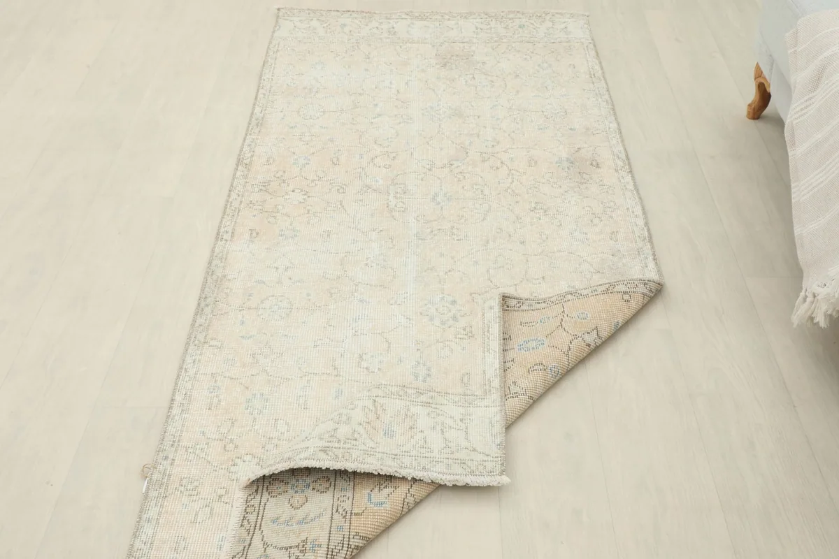 Rug partially folded, showcasing the back and the light patina on the front