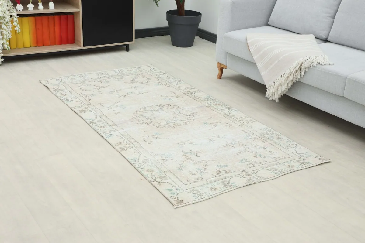 Overhead view of the ivory rug in a room, highlighting its faded colors and medallion design.