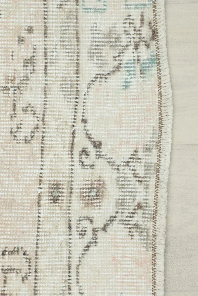 View of the rug's edge, showcasing the hand-knotted construction and the subtle border design.