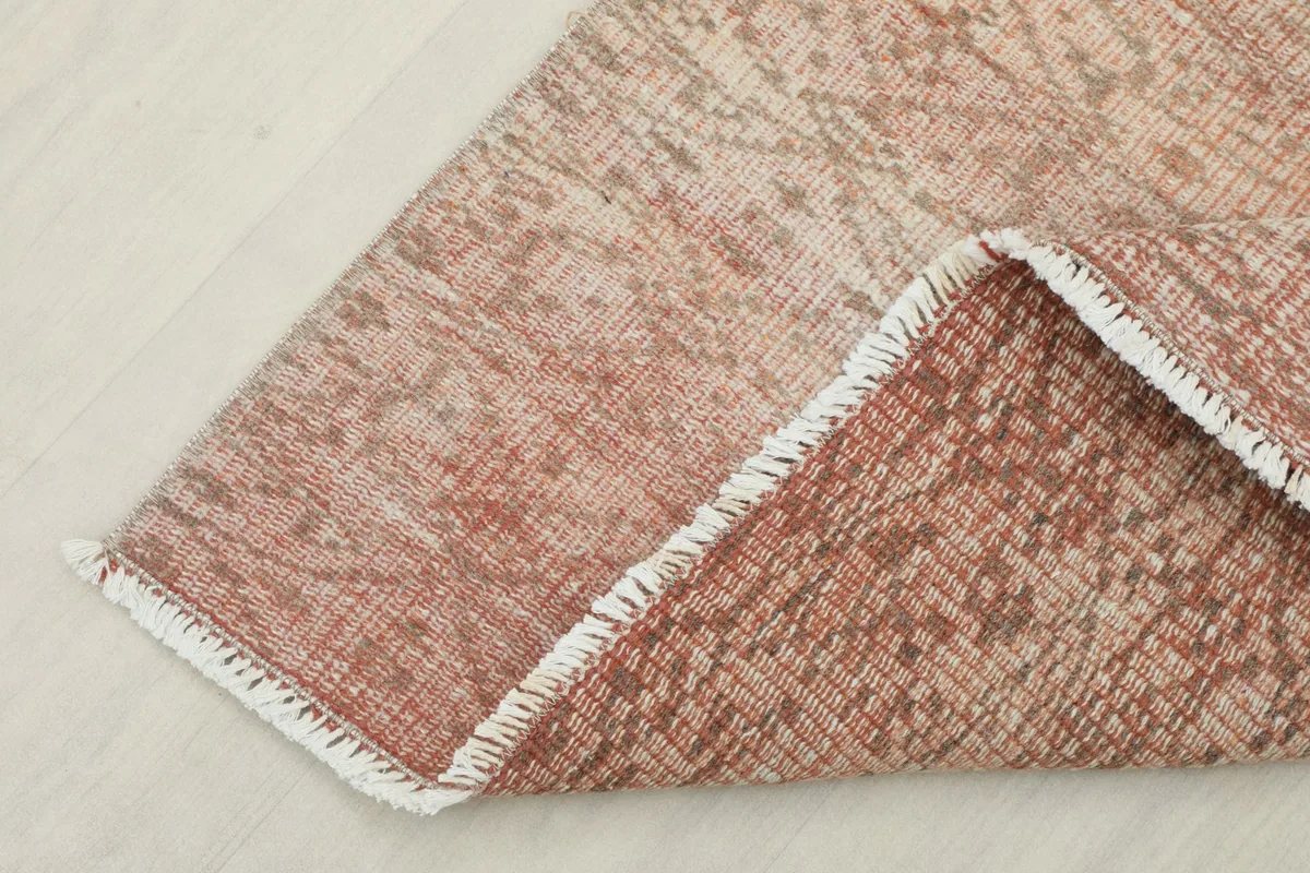 Corner folded back to show the cotton foundation and the reverse side of the hand-knotted rug.
