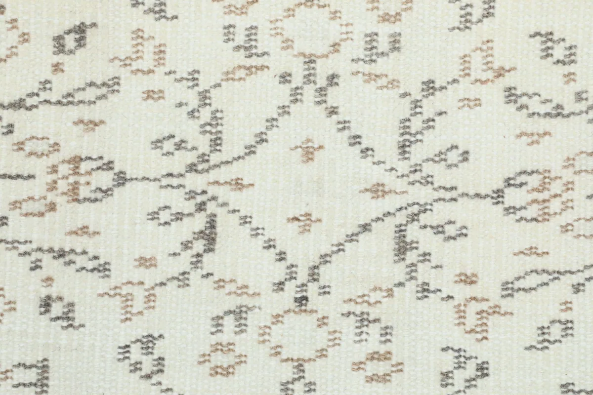 Extreme close-up of the low wool pile, revealing the hand-knotted texture and color variations.