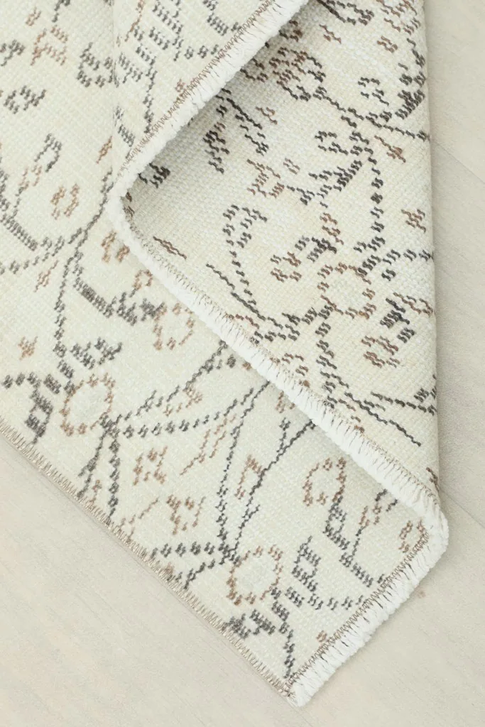 View of the back of the rug, showing the cotton foundation and fine hand-knotted construction.