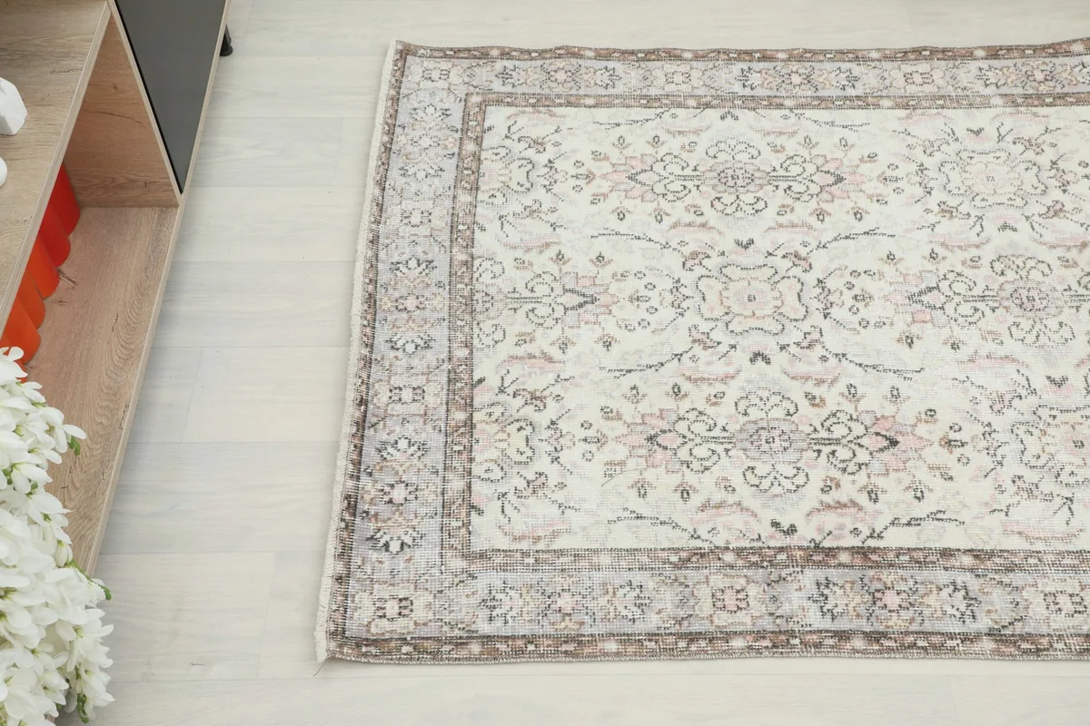 Overhead angle view of the vintage rug, capturing its delicate floral and geometric patterns
