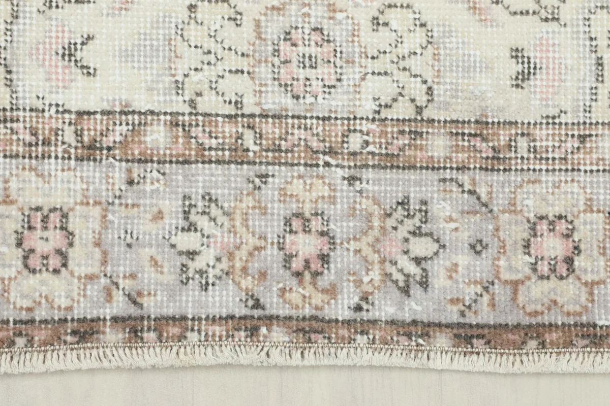Detailed view of the rug's border, showcasing the geometric patterns and color variations