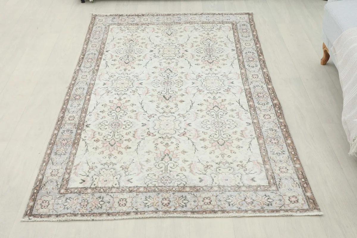 Full overhead view of the cream and rose vintage Anatolian rug on a light floor