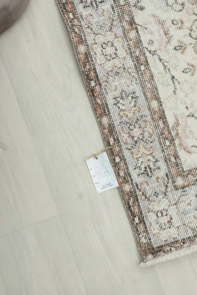 Small tag near the border of the rug, indicating product details