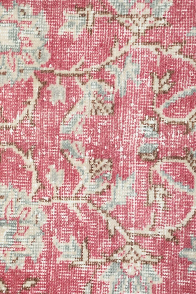 Detailed view of the low wool pile and hand-knotted texture, showcasing the intricate floral weaving.