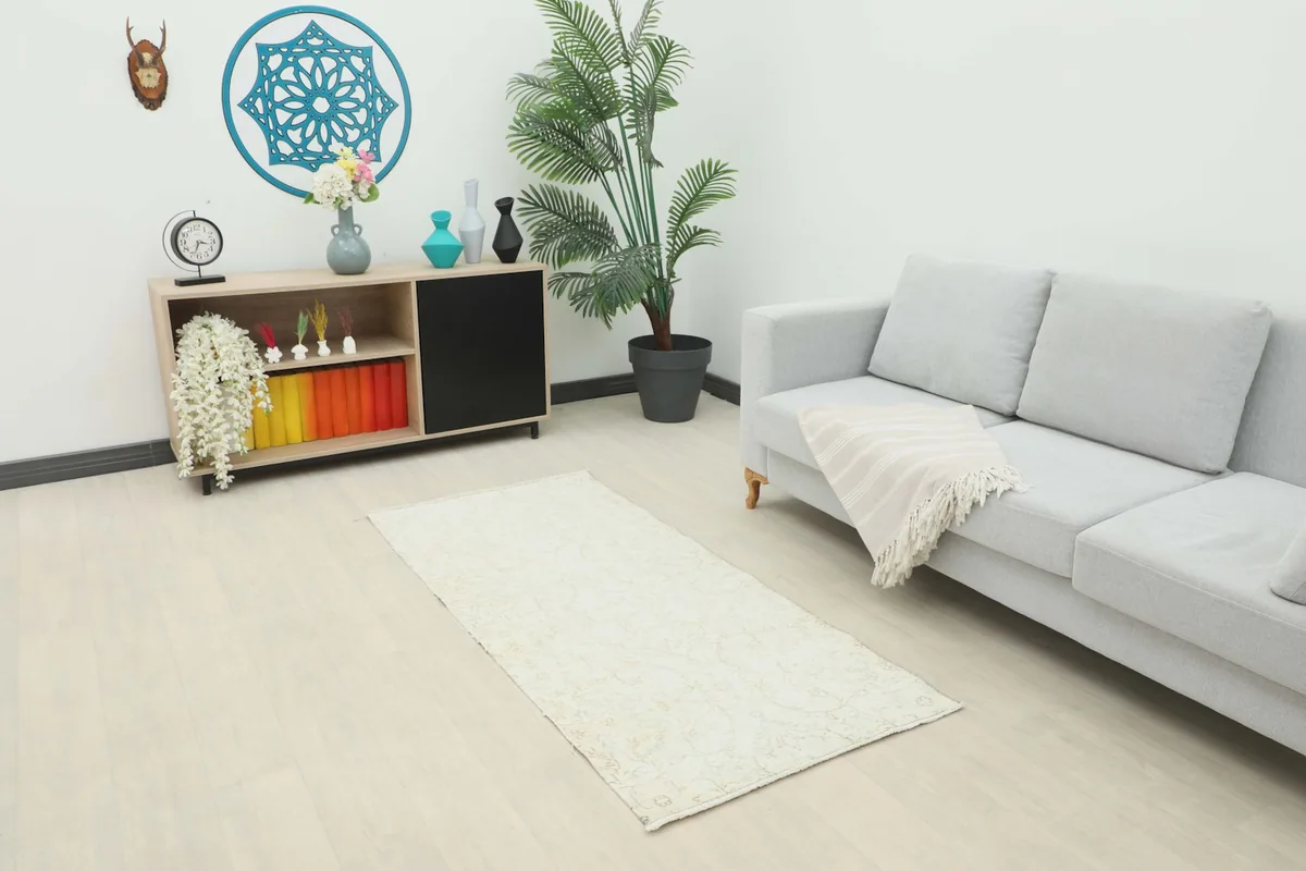 Cream floral runner placed in a living room setting with a light gray sofa and modern decor.