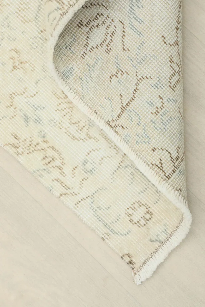 View of the rug's underside, showing the cotton foundation and hand-knotted construction.