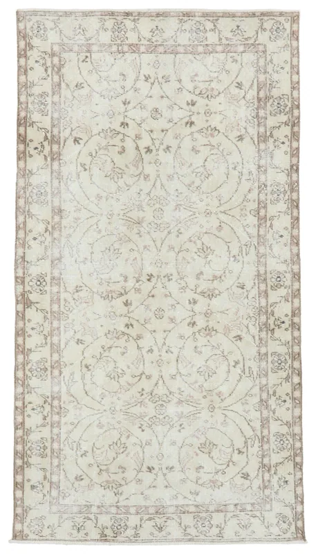 Full overhead view of the 3'7" x 6'9" ivory and tan floral vintage Anatolian rug