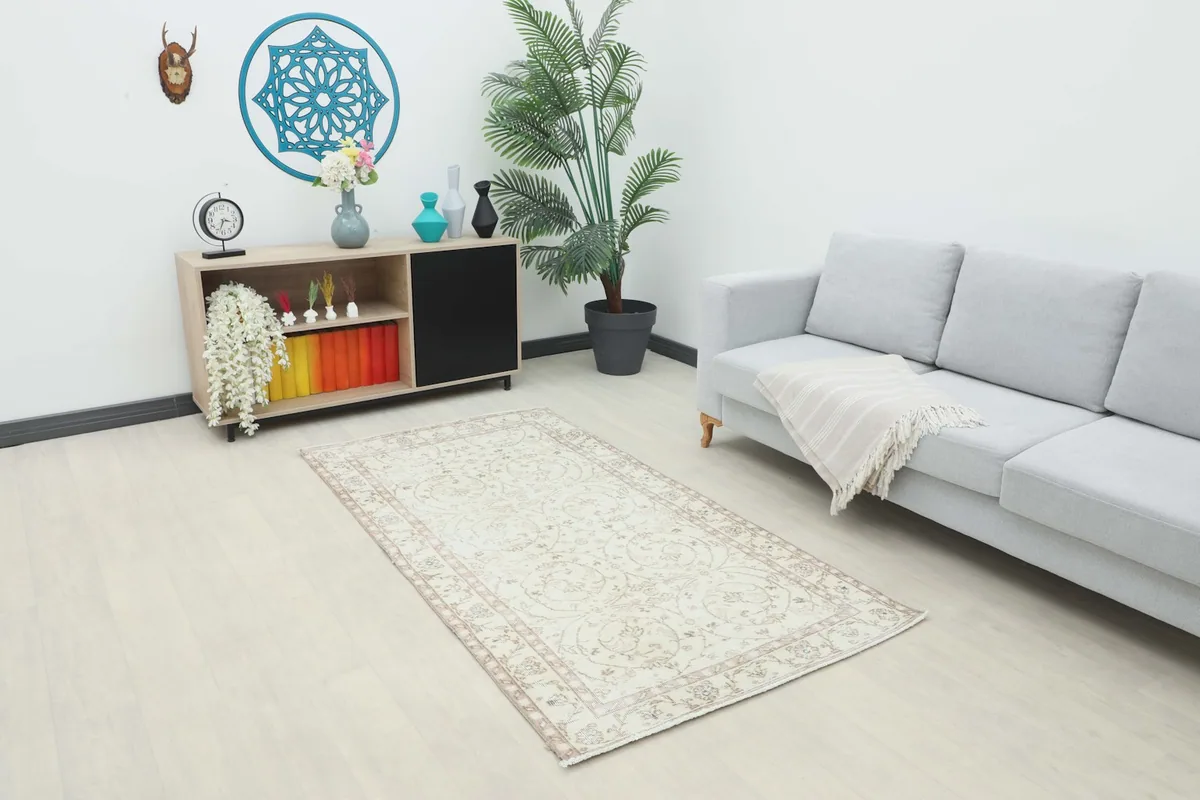 Vintage Anatolian rug placed in a modern living room setting with a gray sofa