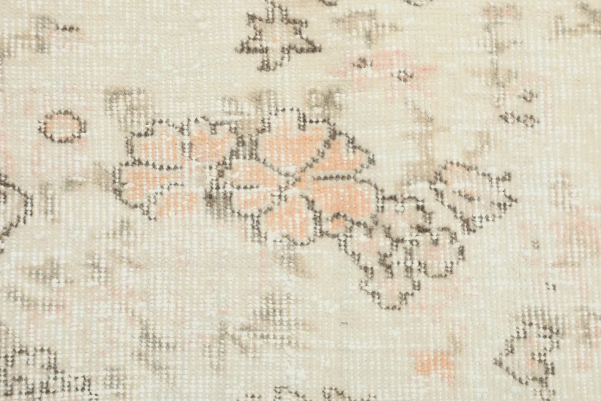 Extreme close-up of the rug's low wool pile, showing individual knots and design details