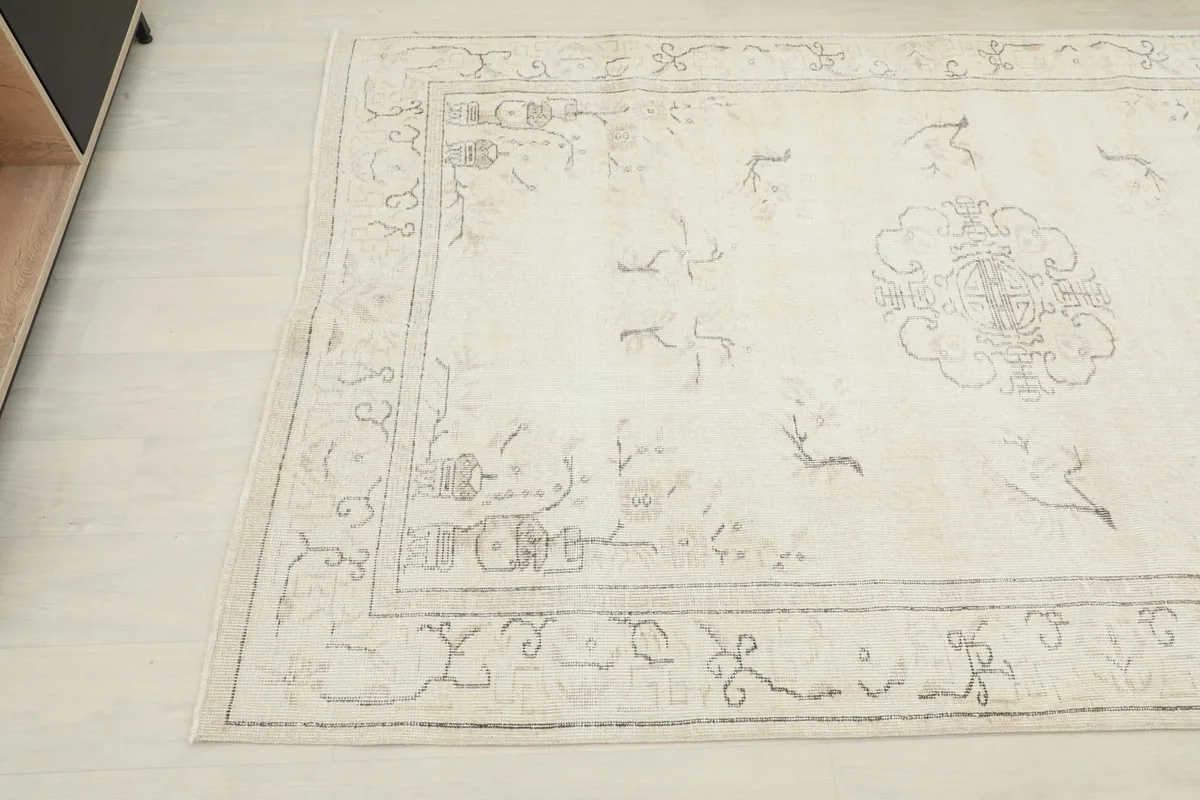 Corner view of the vintage Anatolian rug highlighting its soft ivory and beige tones.