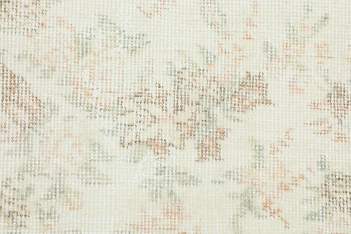 Extreme close-up of the low wool pile, revealing the hand-knotted texture and faded colors