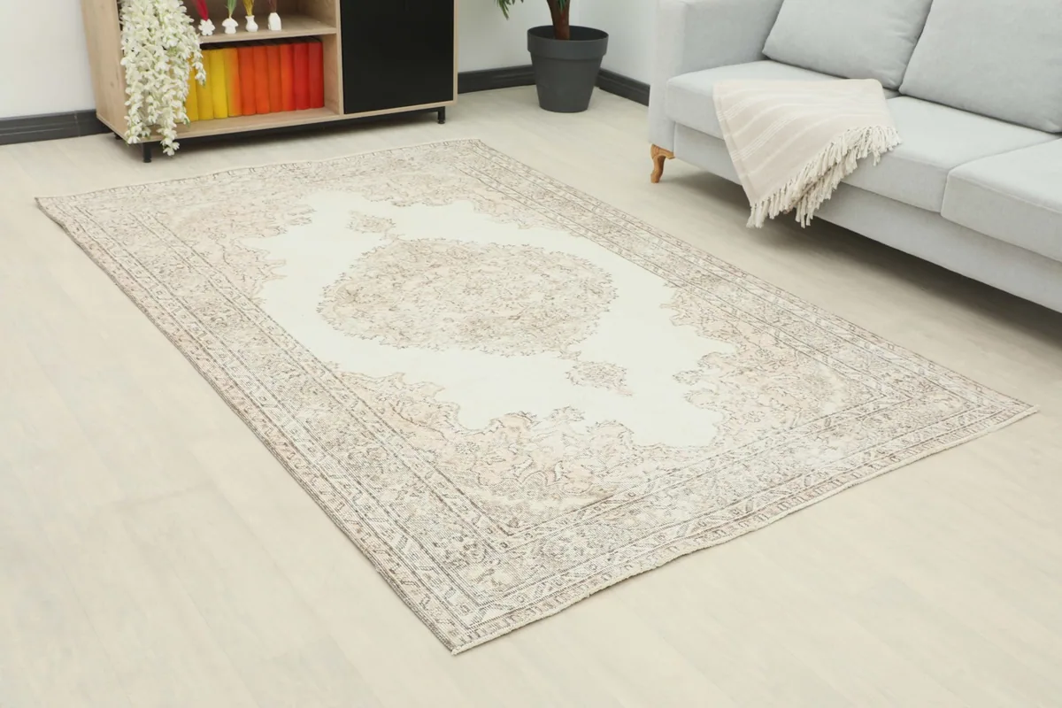 Angle view of the ivory and beige area rug in a living room, showing its size in relation to furniture.