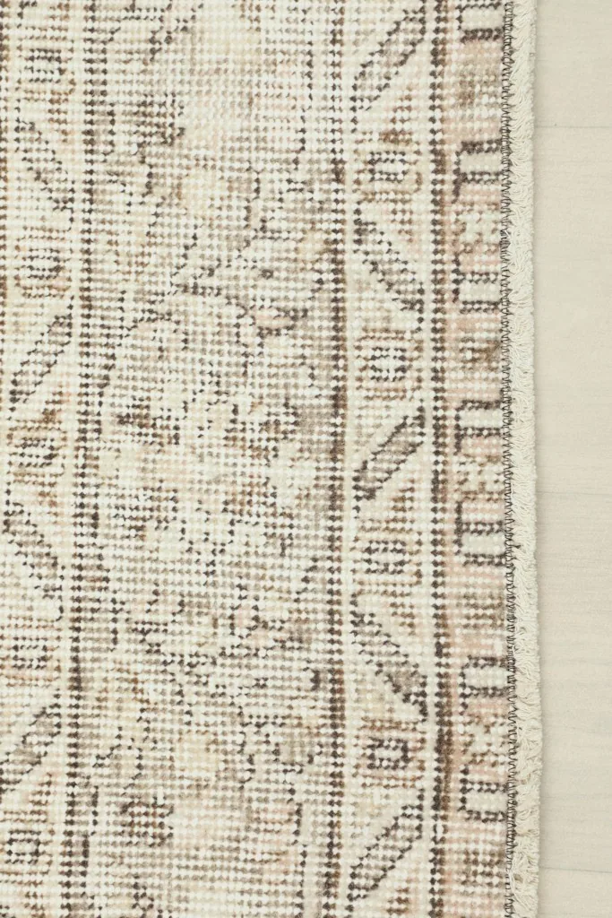 Close-up of the low wool pile and the hand-knotted structure along the rug's edge.