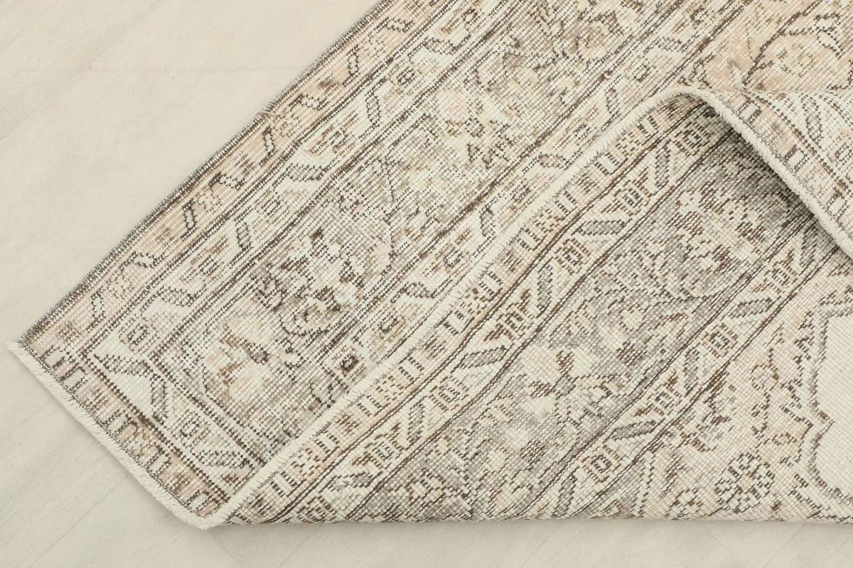 Detailed shot of the folded corner, revealing the cotton foundation and the back of the hand-knotted pile.