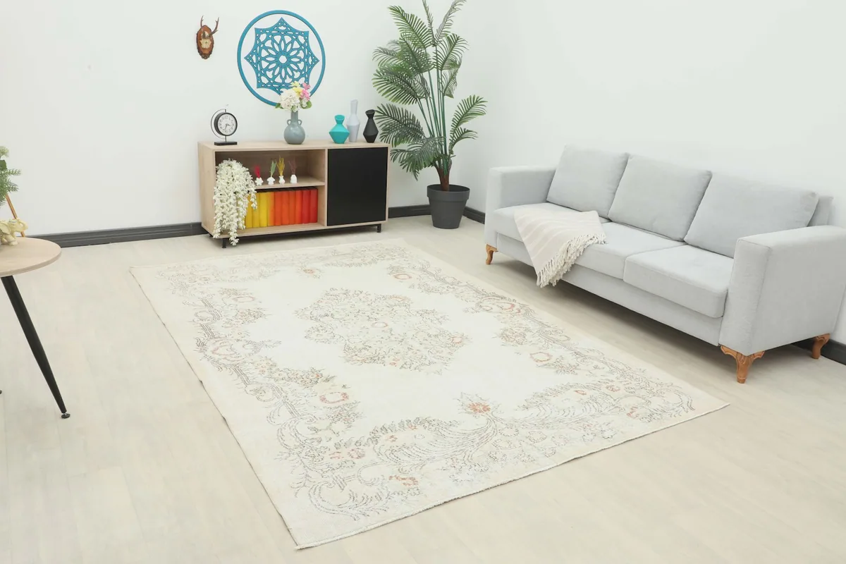 Ivory vintage rug displayed in a modern living room setting with a light gray sofa.