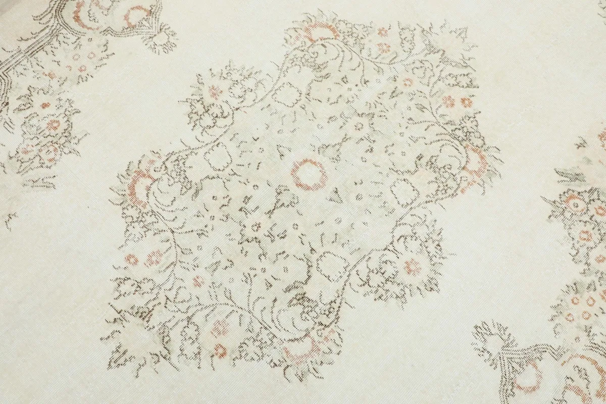 Close-up of the central medallion motif, showing the intricate floral details and muted colors.