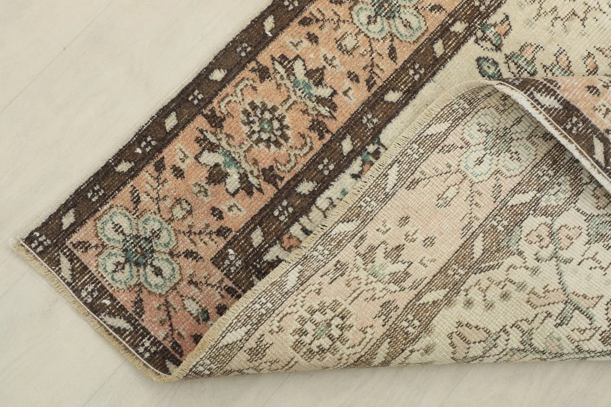 Corner of the rug folded to show the wool pile and cotton foundation