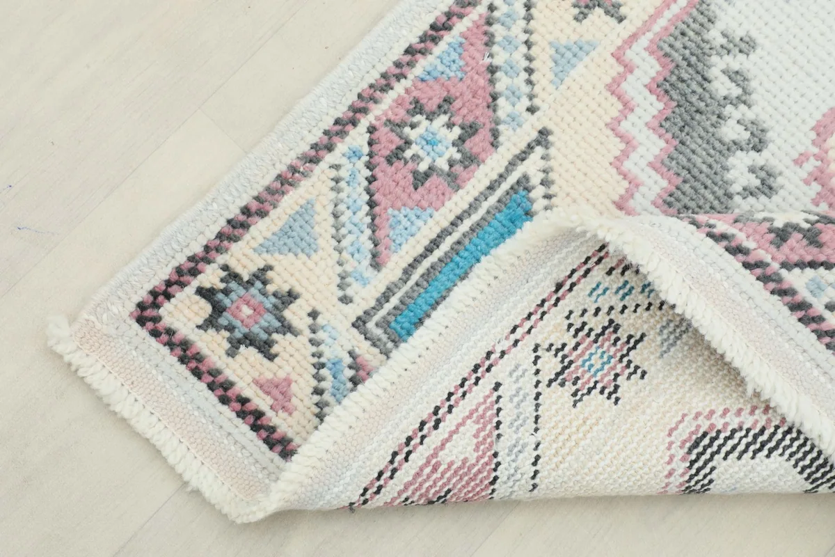 Corner of the runner folded to reveal the reverse side, showing the hand-knotted construction.