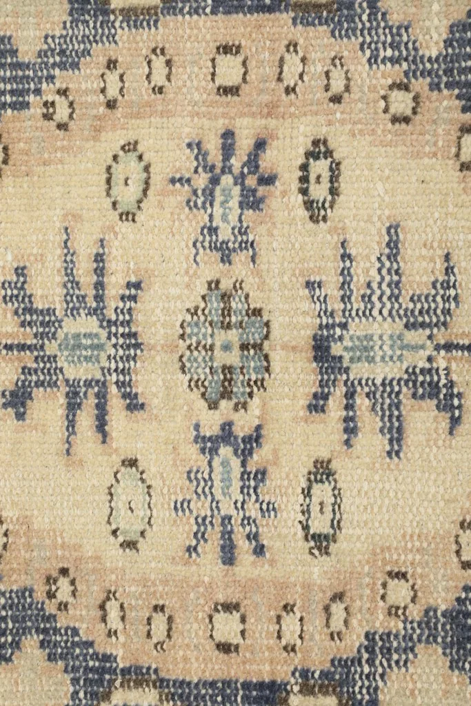Intricate detail of the geometric and floral motifs within the rug's design